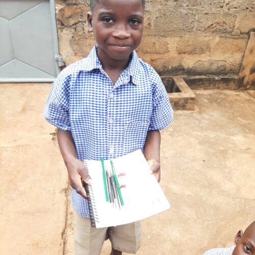 Un enfant content de recevoir ces dons à l’école EPL Le Savoir Universel